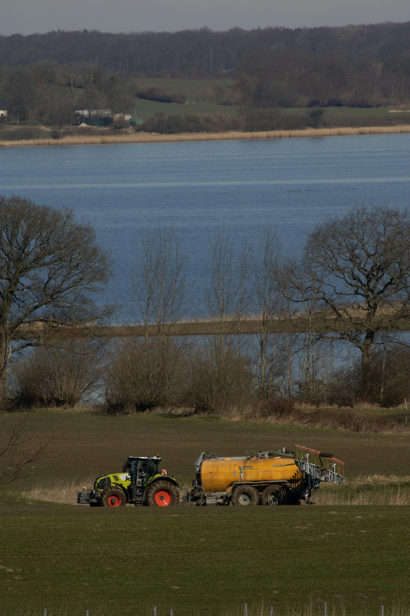 Claas tractor on meadow delivering manure and got stuck